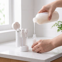 Mova being refilled from a full-size shampoo bottle